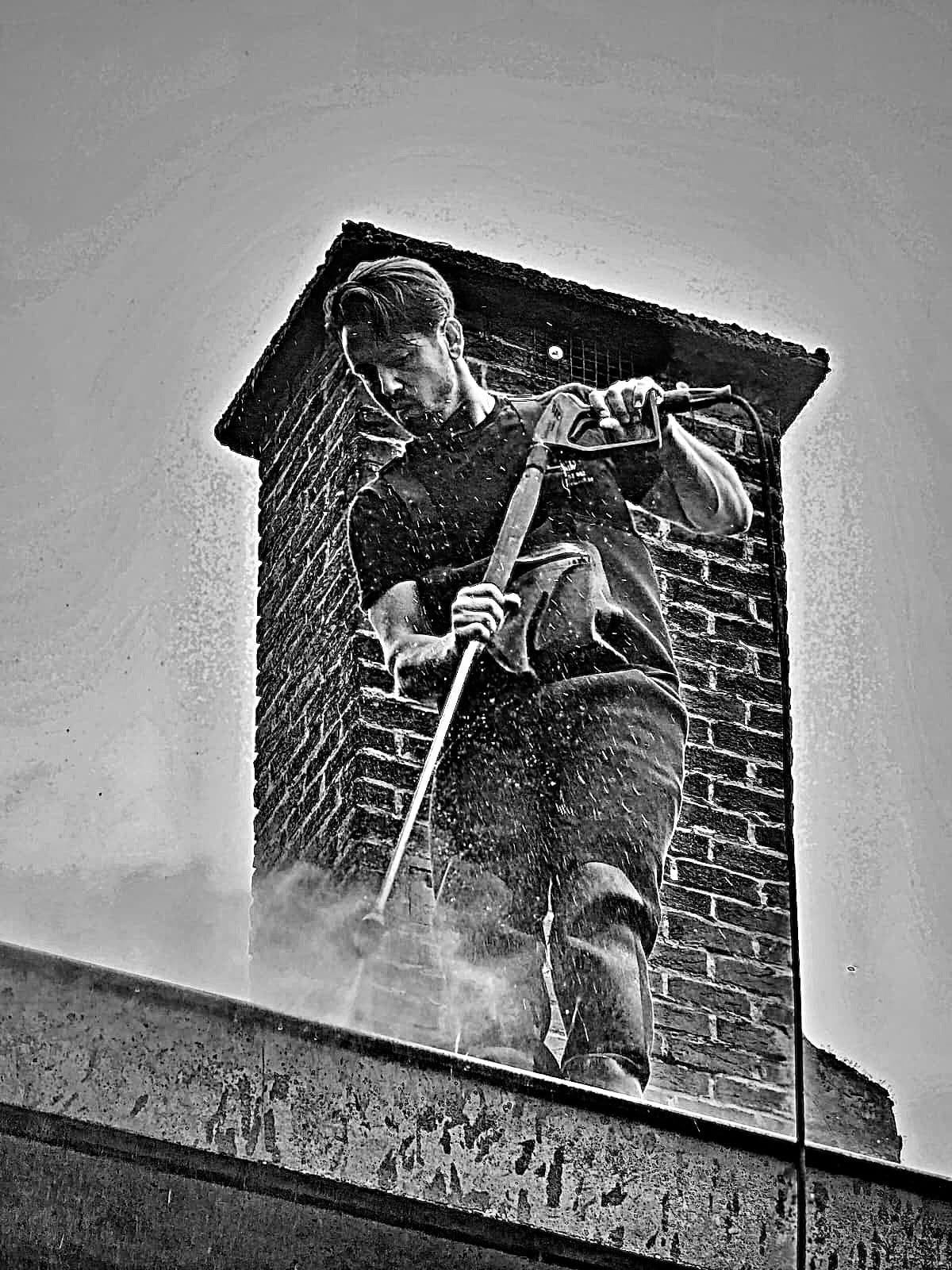 A member of our team, lance in hand, in front of a chimney (black and white photo)
